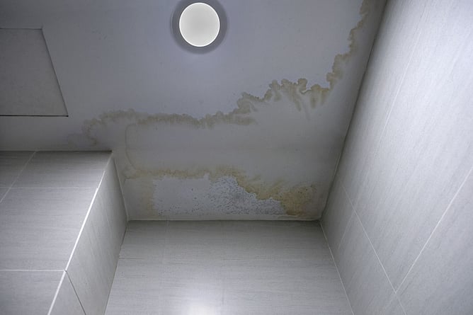 ceiling stained from water damage from a roof that needs replacement