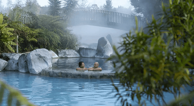Couple relaxing in the natural hot springs of Otumuheke Stream at Spa Thermal Park Taupo