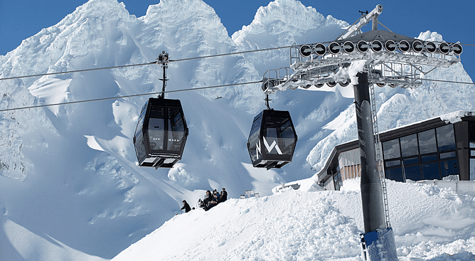 Sky Waka gondola cabins ascending snow-capped Mt Ruapehu at Whakapapa ski field