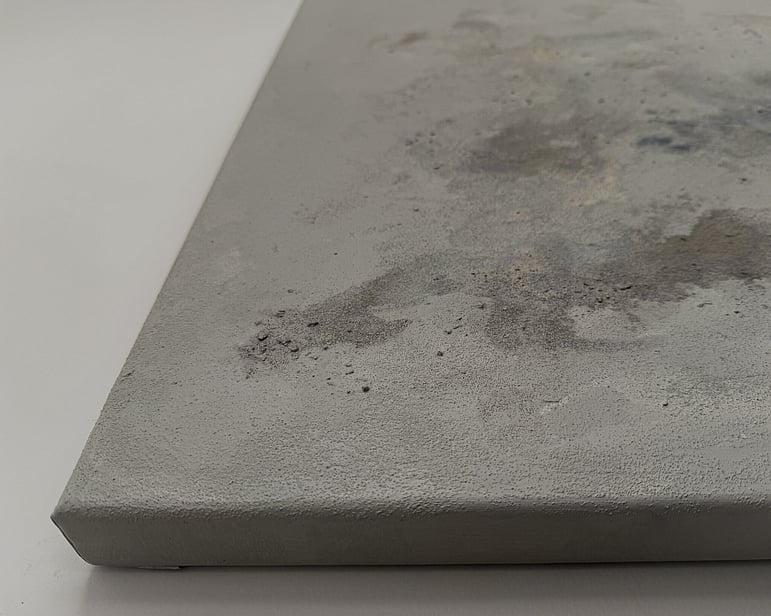 side view of canvas showing raised pumice texture, smooth recessed areas, layered mineral and stone tones and canvas depth