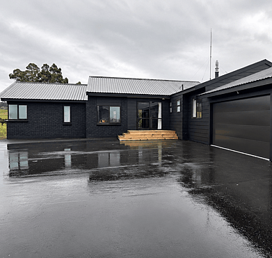 Completed exterior house repaint with modern black finish in Rotorua