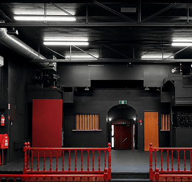 Community theatre interior repainted from burgundy to stage black in Rotorua