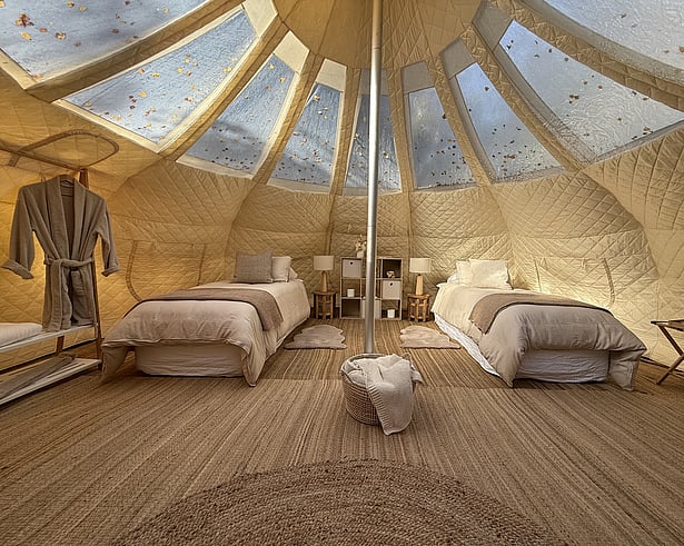     Twin single bed setup inside a Lotus Belle Stargazer tent at Forest Hillside Glamping Retreat.&rdquo;