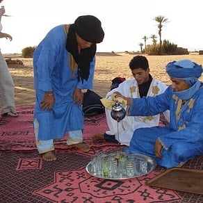 Moroccan tea being served on a rug during the tour