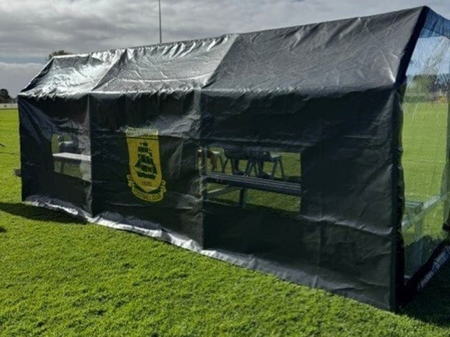 Custom all-weather dugout cover installed pitch-side at local sporting field."