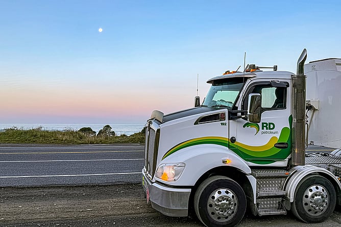 RD Petroleum fuel tanker parked roadside on the Kaikōura Coast at dusk with moon over the ocean