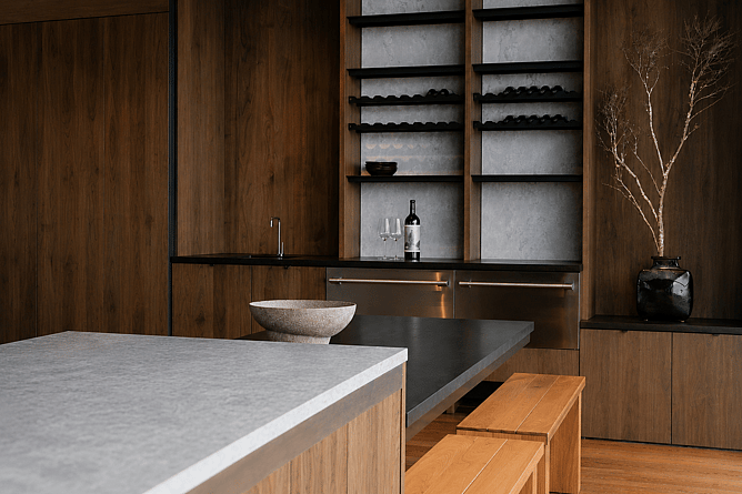 High-end kitchen featuring warm timber cabinetry, stone benchtops and integrated appliances