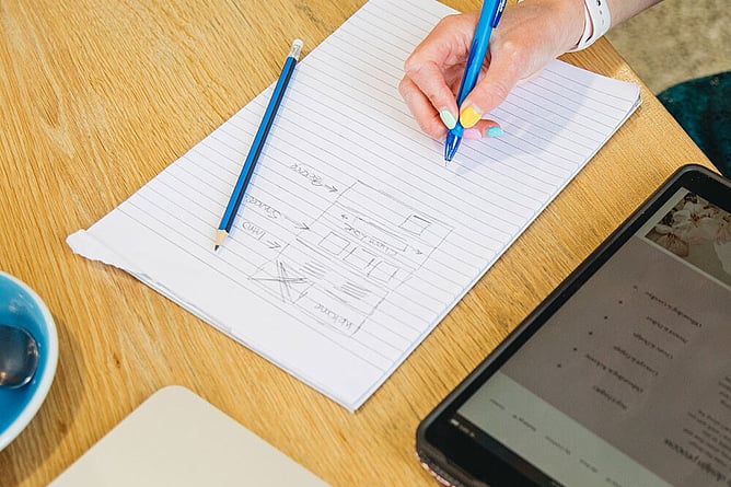 Woman sketching ideas for brand collateral