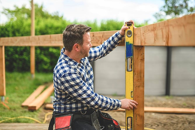 builder measuring up a fence for new build
