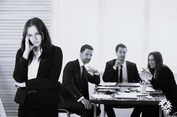 Person sitting alone at a desk, reflecting on a difficult workplace situation