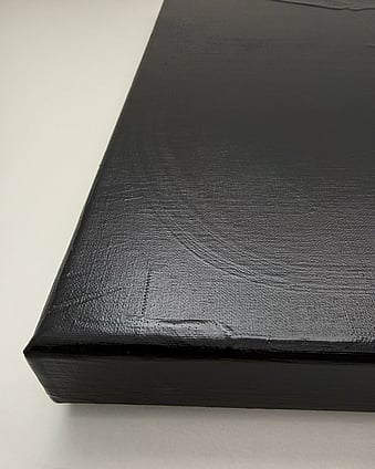 side view of warm black abstract painting on linen, showing a predominantly smooth acrylic surface with subtle brush marks, variations in sheen and canvas depth