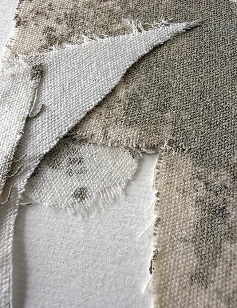 detail image of layered repurposed pale cream cotton fragments blotted with green-grey acrylic, showing visible weave texture and soft frayed edges 