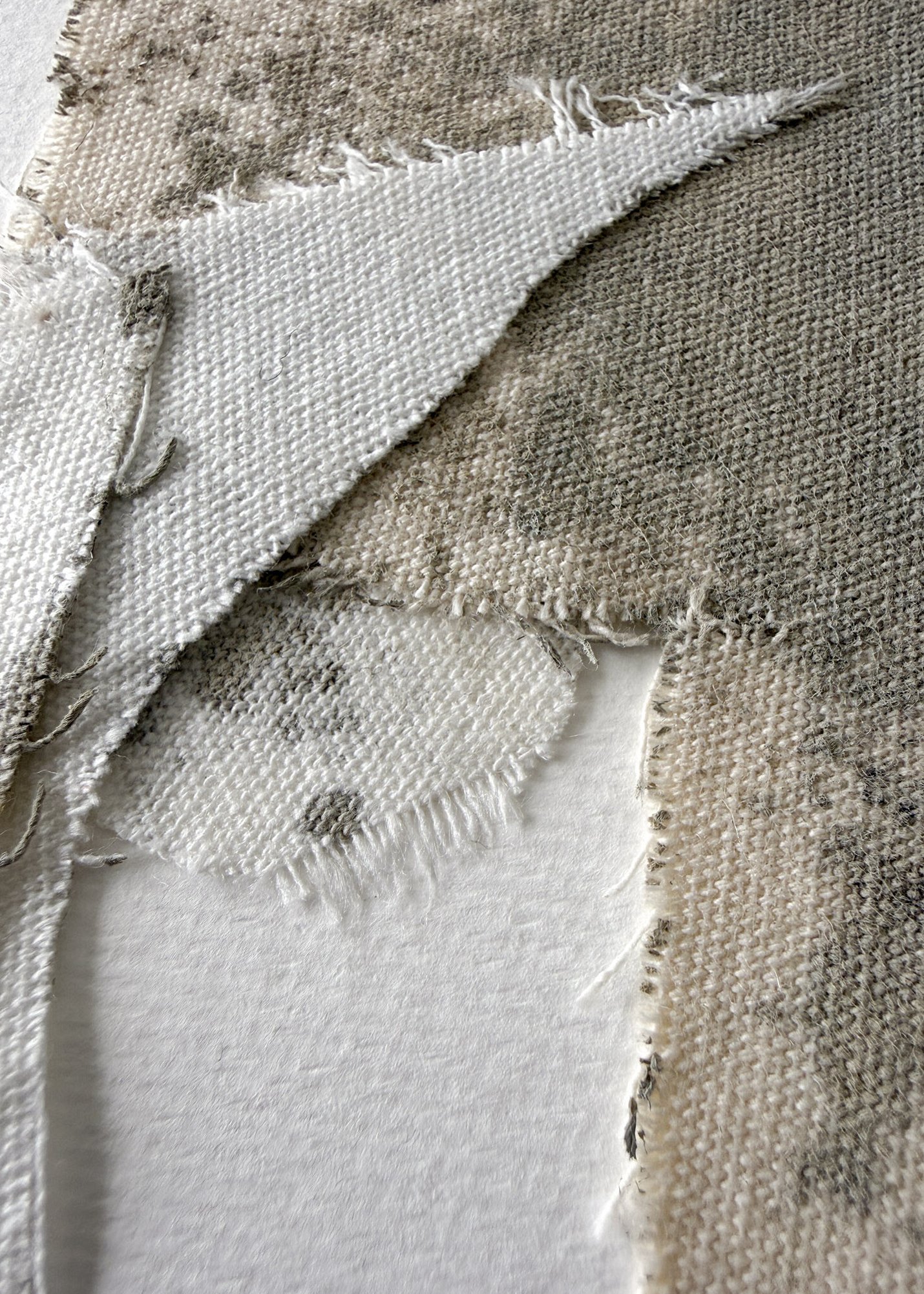 full image of a layered collage of pale cream cotton fragments blotted with green-grey acrylic, showing soft frayed edges on ivory fabriano and handwritten signature in lower right corner