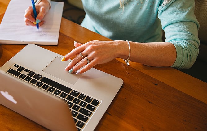 Wedding professional reviewing brand strategy on laptop to attract high-value clients
