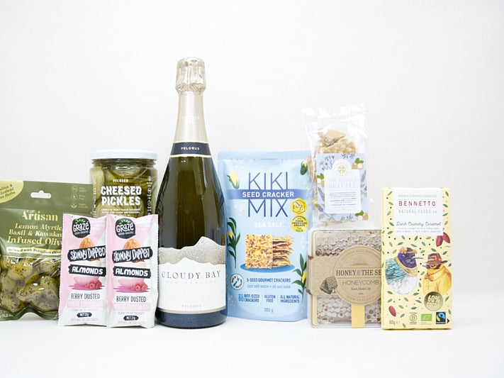 Congratulations Gift Box featuring Cloudy Bay Pelorus sparkling wine, artisan olives, pickled cucumbers, Kiki Seed Crackers, Sesh honey, Bennetto salted caramel chocolate, Skinny Dipped almonds, and macadamia brittle superseeds, beautifully packaged for celebrations and milestone gifting.