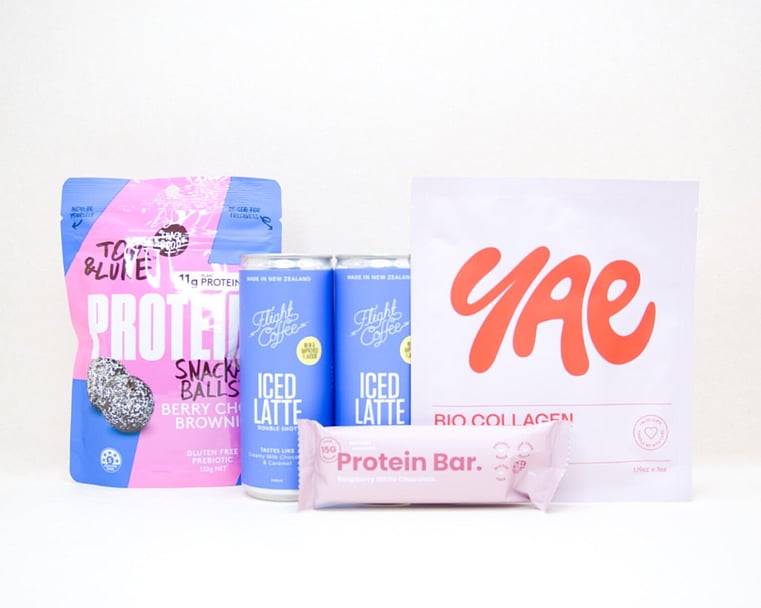 A Little Boost Gift Box featuring Flight Coffee cans, Tom & Luke protein bliss balls, Nothing Naughty protein bar, and a YAE face mask, beautifully packaged as an under $100 gift for coffee lovers and self-care gifting.