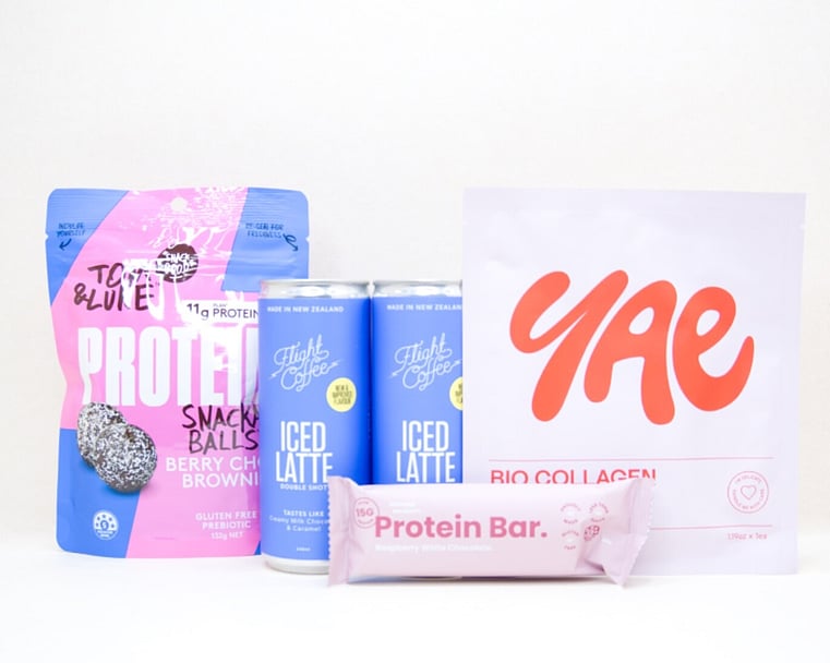 A Little Boost Gift Box featuring Flight Coffee cans, Tom & Luke protein bliss balls, Nothing Naughty protein bar, and a YAE face mask, beautifully packaged as an under $100 gift for coffee lovers and self-care gifting.