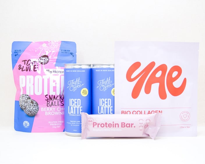 A Little Boost Gift Box featuring Flight Coffee cans, Tom & Luke protein bliss balls, Nothing Naughty protein bar, and a YAE face mask, beautifully packaged as an under $100 gift for coffee lovers and self-care gifting.
