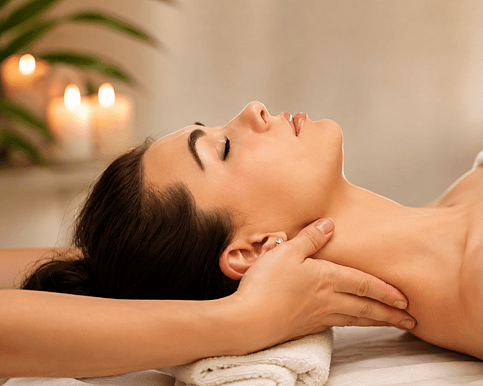 A picture of a lady lying on her back and the therapist has her hand gently massaging her neck