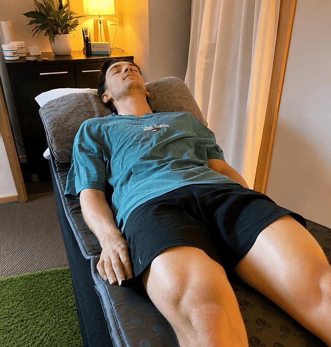 Picture of a young man lying on the pemf mat