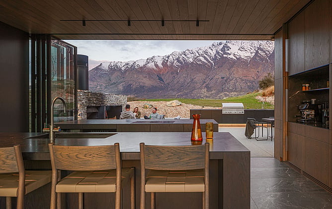Modern Wānaka home with open-plan kitchen and living area overlooking snow-capped mountains