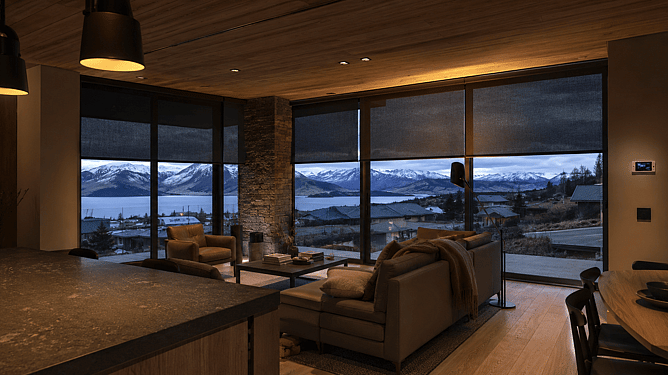 Queenstown luxury living room with motorised blinds, smart lighting, and floor-to-ceiling windows overlooking snow-capped mountains and lake