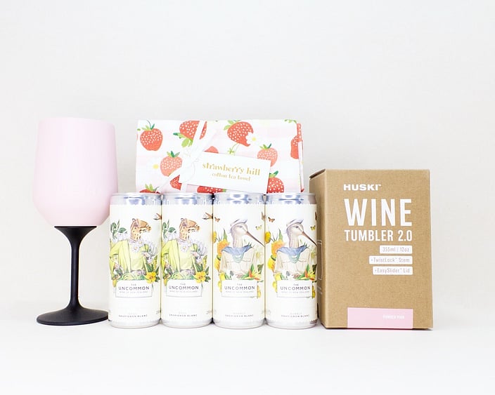 Let's Celebrate Gift Box featuring The Uncommon Sauvignon Blanc and Bubbly wine cans, a HUSKI wine tumbler or flute, and a Strawberry Hill tea towel, thoughtfully curated for birthdays, celebrations, thank you gifts, and life's special moments.