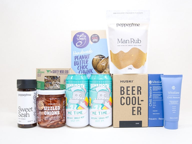 Well Earned Gift Box featuring Behemoth Me Time craft beers, a HUSKI beer cooler, Pepper & Me Man Rub, Hot Honey, Vitalize muscle rub, sizzled onions, Molly Woppy Peanut Butter Choc Chunk Cookies, and a Crafty Weka bar, thoughtfully curated for craft beer lovers, BBQ enthusiasts, and gifts for him