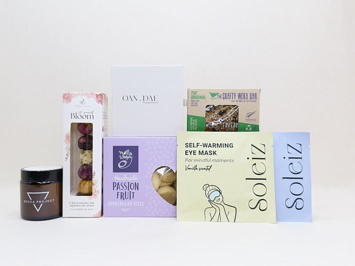 Mindful Moment self-care gift box with Soleiz eye masks, herbal tea balls, OAN DAE wish kit, Molly Woppy cookies, wellness products, and wholesome treats, designed to encourage rest, mindfulness, and everyday self-care