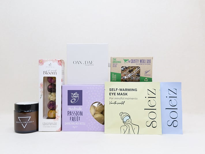 Mindful Moment self-care gift box with Soleiz eye masks, herbal tea balls, OAN DAE wish kit, Molly Woppy cookies, wellness products, and wholesome treats, designed to encourage rest, mindfulness, and everyday self-care