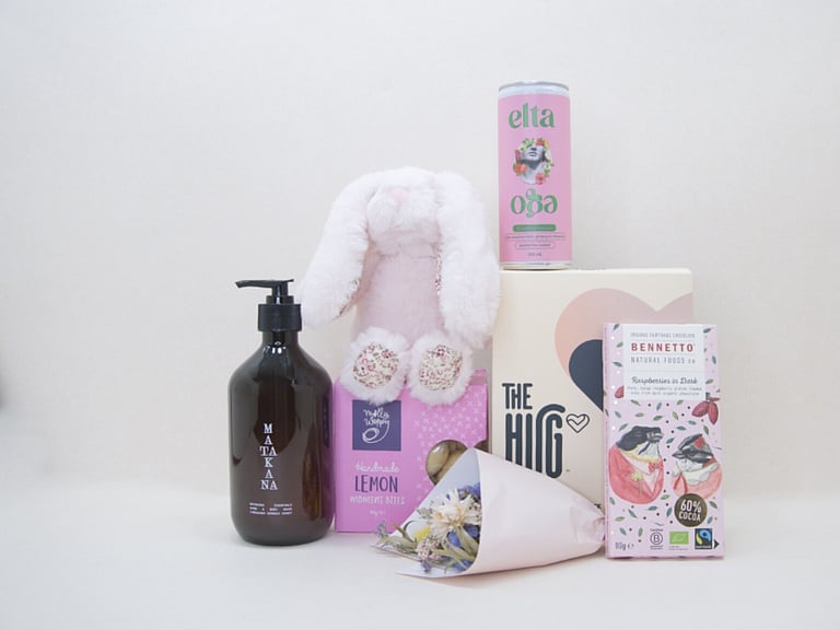 A Hug for Mum Gift Box featuring The HUG hot and cold gel pack, alcohol-free passionfruit cocktail, dried flowers, body wash, artisan chocolate, sweet treats, and a Lily & George teddy, beautifully presented in a premium KYND gift box.
