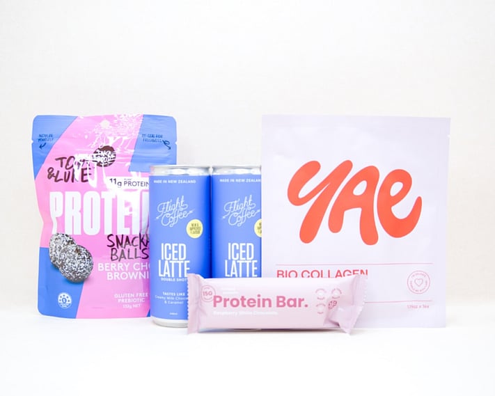 A Little Boost Gift Box featuring Flight Coffee cans, Tom & Luke protein bliss balls, Nothing Naughty protein bar, and a YAE face mask, beautifully packaged as an under $100 gift for coffee lovers and self-care gifting.