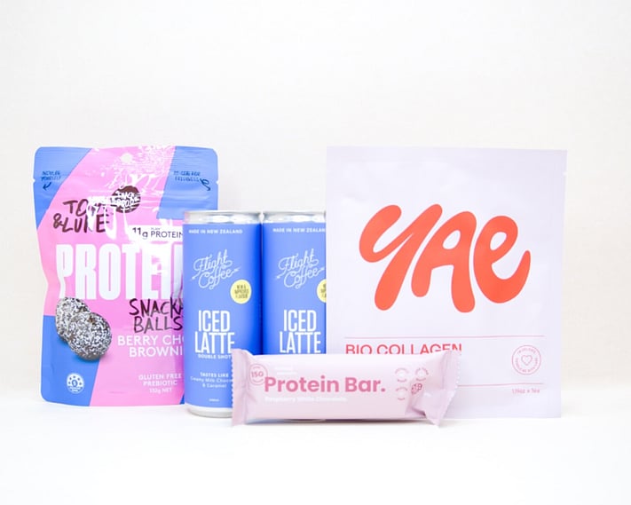 A Little Boost Gift Box featuring Flight Coffee cans, Tom & Luke protein bliss balls, Nothing Naughty protein bar, and a YAE face mask, beautifully packaged as an under $100 gift for coffee lovers and self-care gifting.