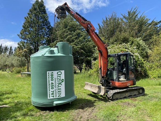 digger holding up septic tank