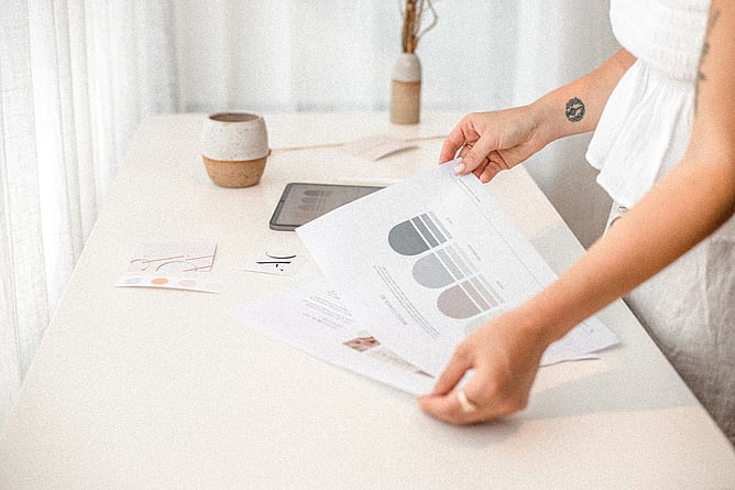 Graphic designer reviewing brand colours and visual identity materials for a small business.