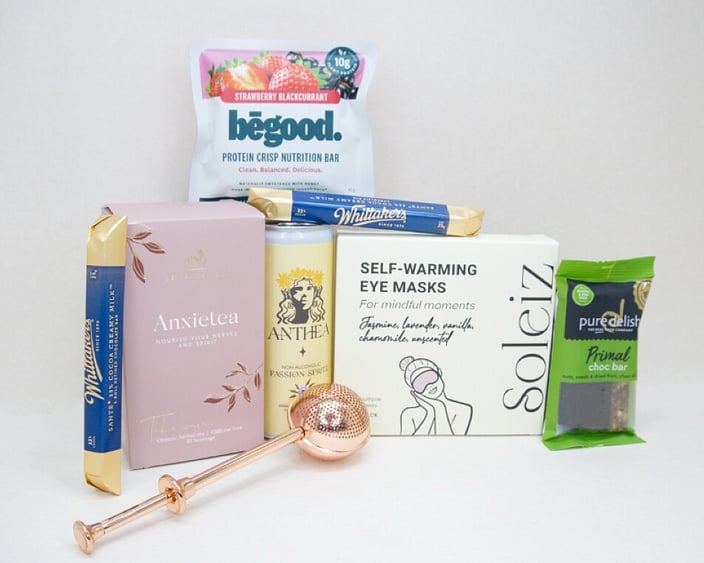 Take It Easy Gift Box featuring Better Tea Co Anxietea tea leaves, tea infuser strainer, Be Good protein bar, Whittaker's Sante bars, and Pure Delish chocolate, beautifully packaged as a calming self-care and wellness gift.