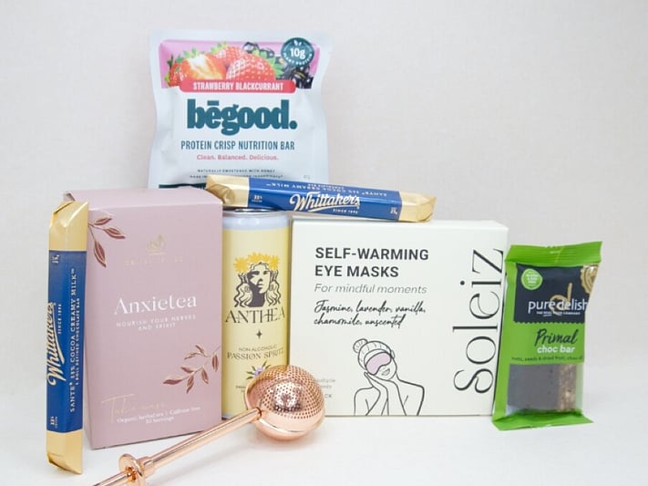 Take It Easy Gift Box featuring Better Tea Co Anxietea tea leaves, tea infuser strainer, Be Good protein bar, Whittaker's Sante bars, and Pure Delish chocolate, beautifully packaged as a calming self-care and wellness gift.