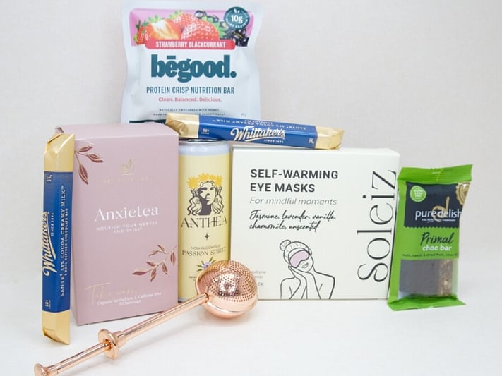 Take It Easy Gift Box featuring Better Tea Co Anxietea tea leaves, tea infuser strainer, Be Good protein bar, Whittaker's Sante bars, and Pure Delish chocolate, beautifully packaged as a calming self-care and wellness gift.