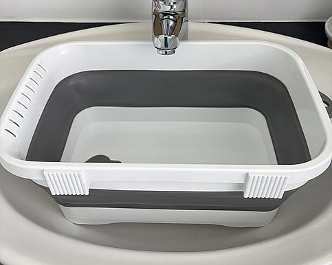 Picture of a portable washing basin that is sitting inside a bathroom sink