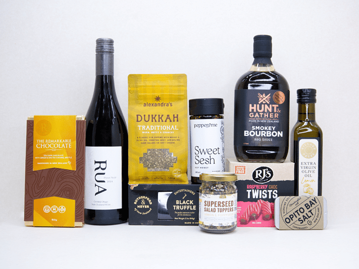 The Foodie gift box featuring Rua Pinot Noir, black truffle crackers, dukkah, lemon olive oil, hot honey, gourmet seasonings, artisan chocolate, caramel brittle, and premium New Zealand pantry favourites, beautifully packaged for food lovers and entertaining.