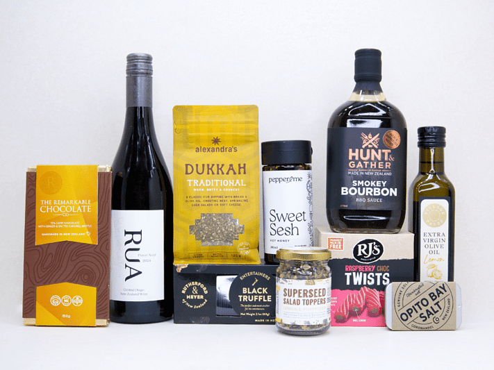 The Foodie gift box featuring Rua Pinot Noir, black truffle crackers, dukkah, lemon olive oil, hot honey, gourmet seasonings, artisan chocolate, caramel brittle, and premium New Zealand pantry favourites, beautifully packaged for food lovers and entertaining.