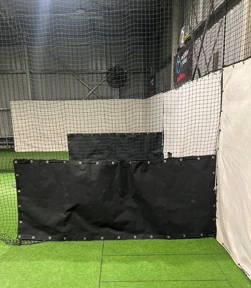 Custom-sized black canvas buffer cover fitted within cricket netting