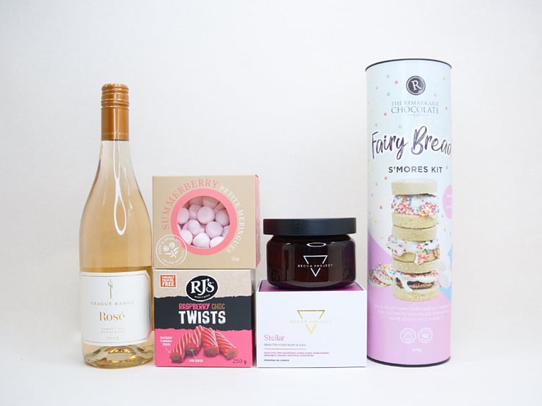Birthday Girl gift box featuring Craggy Range Rosé, Becca Project candle, Remarkable S'mores chocolate, RJ's Raspberry Chocolate Twists, and strawberry petite meringues, beautifully packaged as a birthday gift box for her.