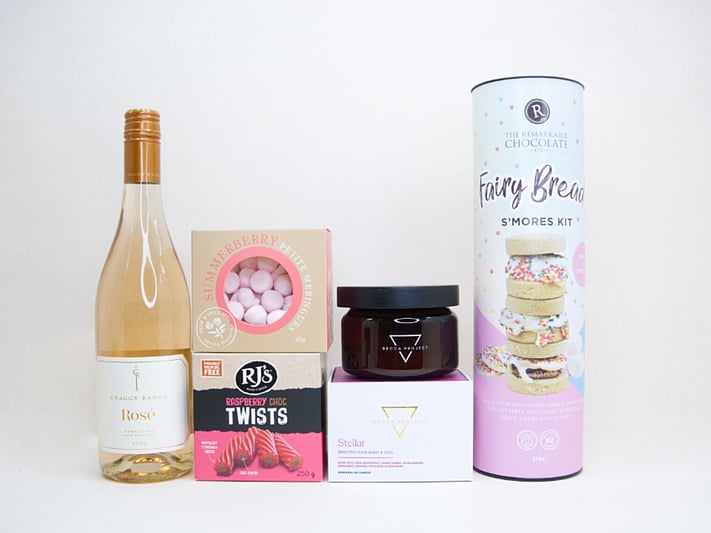 Birthday Girl gift box featuring Craggy Range Rosé, Becca Project candle, Remarkable S'mores chocolate, RJ's Raspberry Chocolate Twists, and strawberry petite meringues, beautifully packaged as a birthday gift box for her.