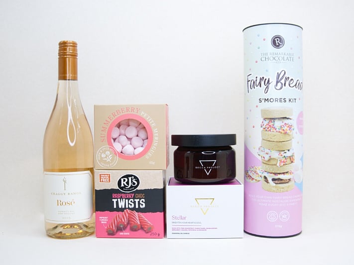 Birthday Girl gift box featuring Craggy Range Rosé, Becca Project candle, Remarkable S'mores chocolate, RJ's Raspberry Chocolate Twists, and strawberry petite meringues, beautifully packaged as a birthday gift box for her.