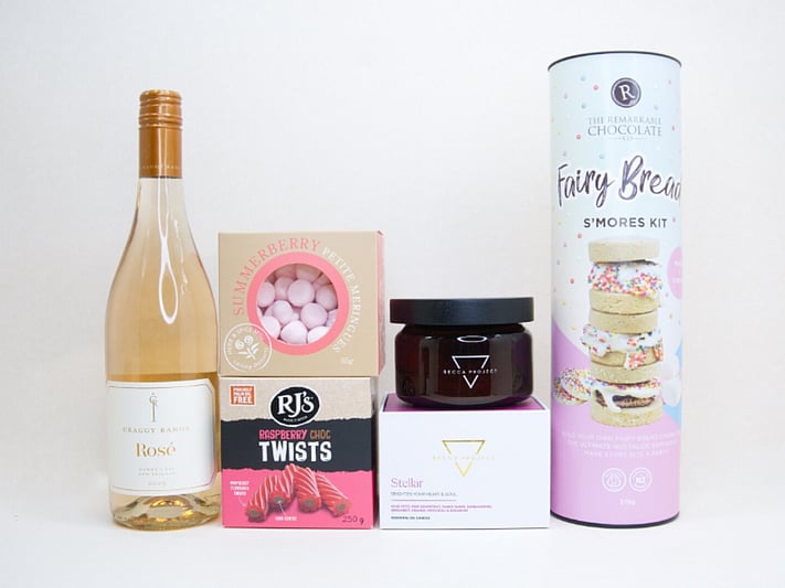 Birthday Girl gift box featuring Craggy Range Rosé, Becca Project candle, Remarkable S'mores chocolate, RJ's Raspberry Chocolate Twists, and strawberry petite meringues, beautifully packaged as a birthday gift box for her.