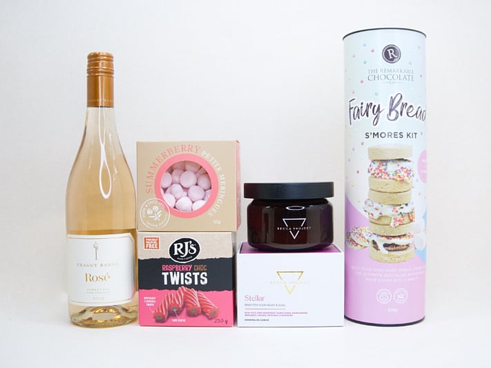 Birthday Girl gift box featuring Craggy Range Rosé, Becca Project candle, Remarkable S'mores chocolate, RJ's Raspberry Chocolate Twists, and strawberry petite meringues, beautifully packaged as a birthday gift box for her.