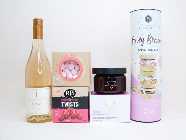 Birthday Girl gift box featuring Craggy Range Ros&eacute;, Becca Project candle, Remarkable S'mores chocolate, RJ's Raspberry Chocolate Twists, and strawberry petite meringues, beautifully packaged as a birthday gift box for her.