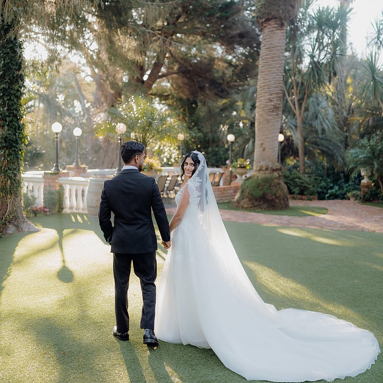 Indian wedding couple walking through the gardens at Settlers Country Manor Auckland.