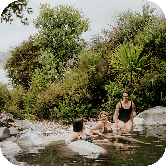People relaxing in the Deluxe Lake Spa pools at Polynesian Spa overlooking Lake Rotorua